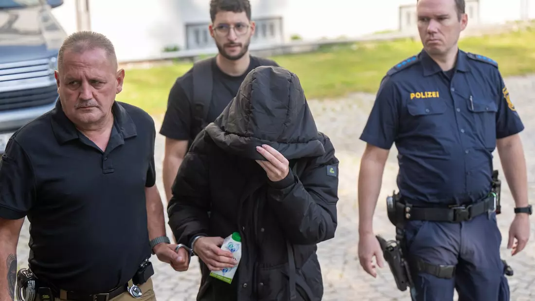 Mit Fußfesseln wird die 39-Jährige in den Gerichtssaal geführt. - Bild: Peter Kneffel/dpa