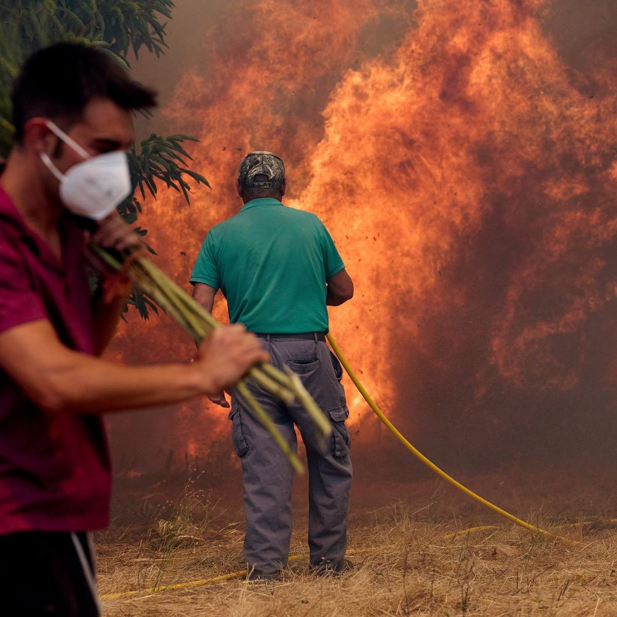 Unermüdlich kämpfen Einsatzkräfte und freiwillige Helfer gegen die Flammen. - Foto: Pablo Garcia/AP/dpa