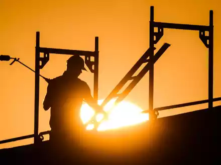 In der prallen Sonne besonders exponiert: Arbeiter auf dem Bau (Archivbild) - Foto: Julian Stratenschulte/dpa