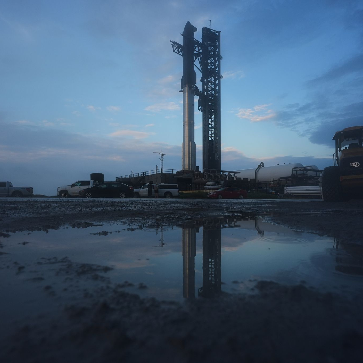 Mehrere Fahnen, darunter zwei mit dem Aufdruck SpaceX und Elon Musk, sind in der Nähe des Startortes. - Foto: Eric Gay/AP/dpa