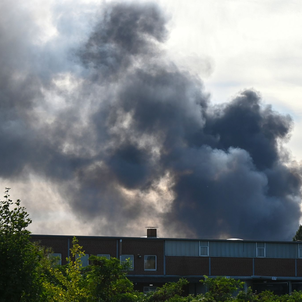 In der Nähe der Autobahn 1 ist eine Rauchwolke zu sehen. - Foto: David Hammersen/dpa