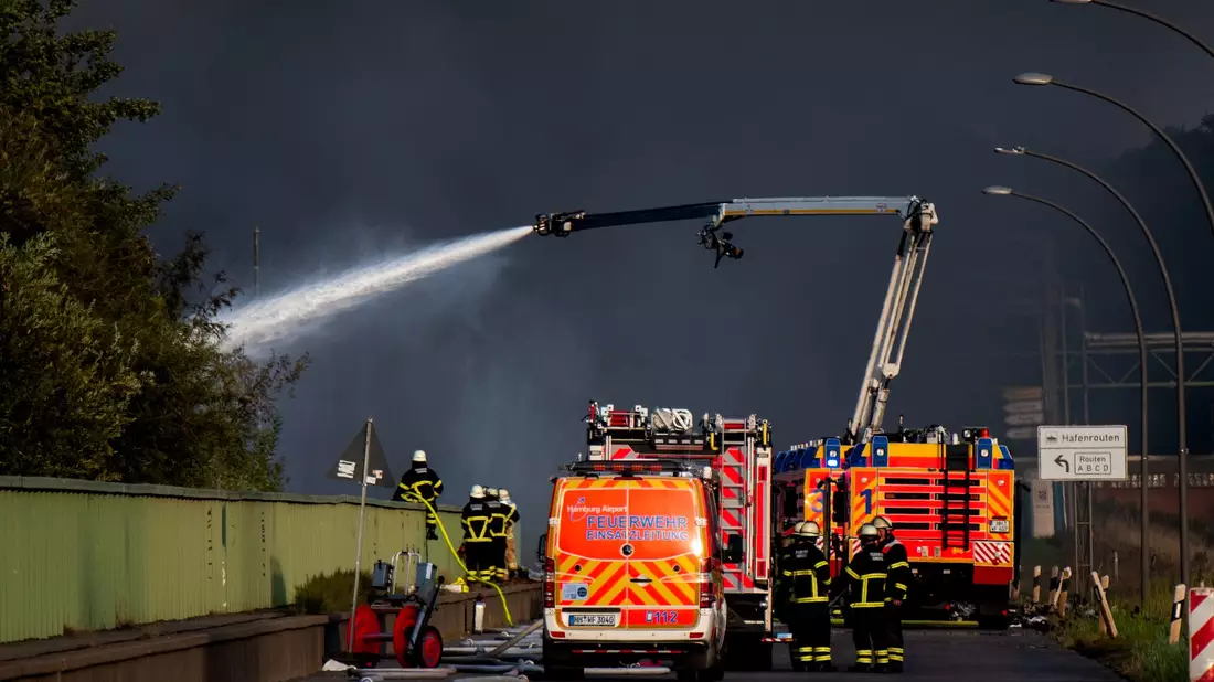 Einsatzkräfte der Feuerwehr versuchen, einen Brand in einem Industriegebiet im Hamburger Hafen zu löschen. - Bild: Daniel Bockwoldt/dpa