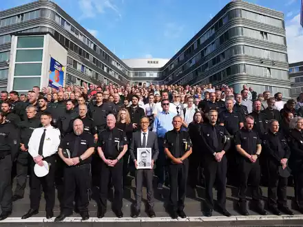 Das saarländische Innenministerium hatte die Polizeibehörden der anderen Länder und des Bundes eingeladen, sich der Gedenkminute anzuschließen. Hier zahlreiche Beamte vor dem Polizeipräsidium in Hamburg. - Foto: Marcus Brandt/dpa