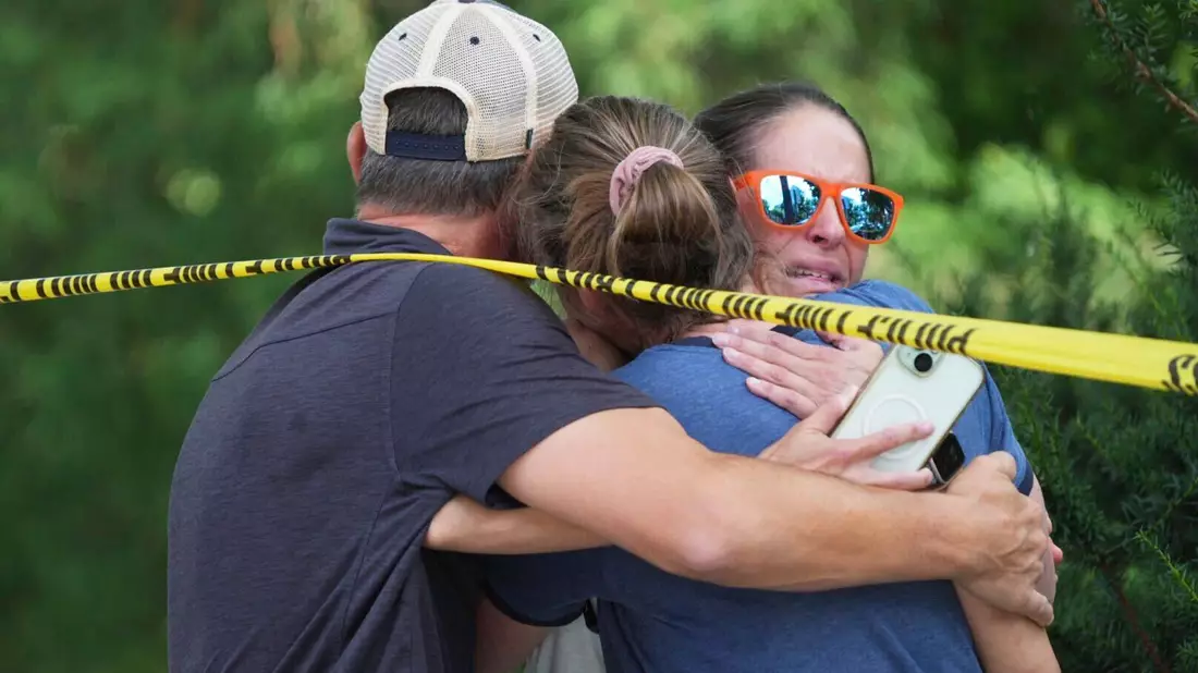 Menschen umarmen sich nach Schüssen an einer Schule, bei denen zwei Kinder gestorben sind. - Bild: Alex Kormann/Star Tribune/AP/dpa