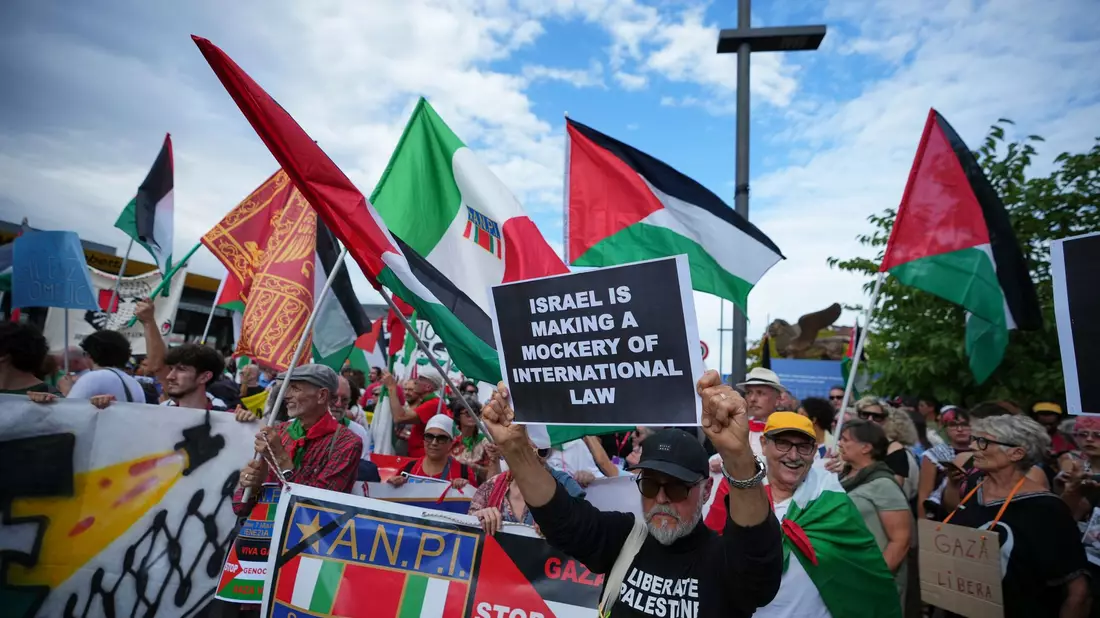 Demonstranten auf dem Weg zur Insel Lido, wo auch das Festival stattfindet.  - Bild: Alessandra Tarantino/Invision/AP/dpa