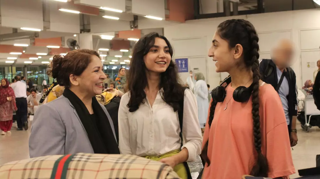 Eine afghanische Frau und ihre Tochter warten am Flughafen in Islamabad. - Bild: Nabila Lalee/dpa
