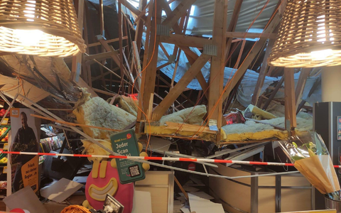 Vom Korb einer Drehleiter heraus kontrolliert ein Feuerwehrmann den eingestürzten Dachbereich. - Foto: Freiwillige Feuerwehr Lauchringen/dpa