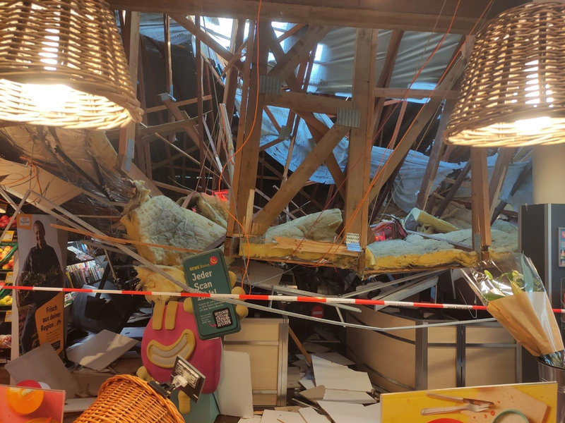 Vom Korb einer Drehleiter heraus kontrolliert ein Feuerwehrmann den eingestürzten Dachbereich. - Foto: Freiwillige Feuerwehr Lauchringen/dpa