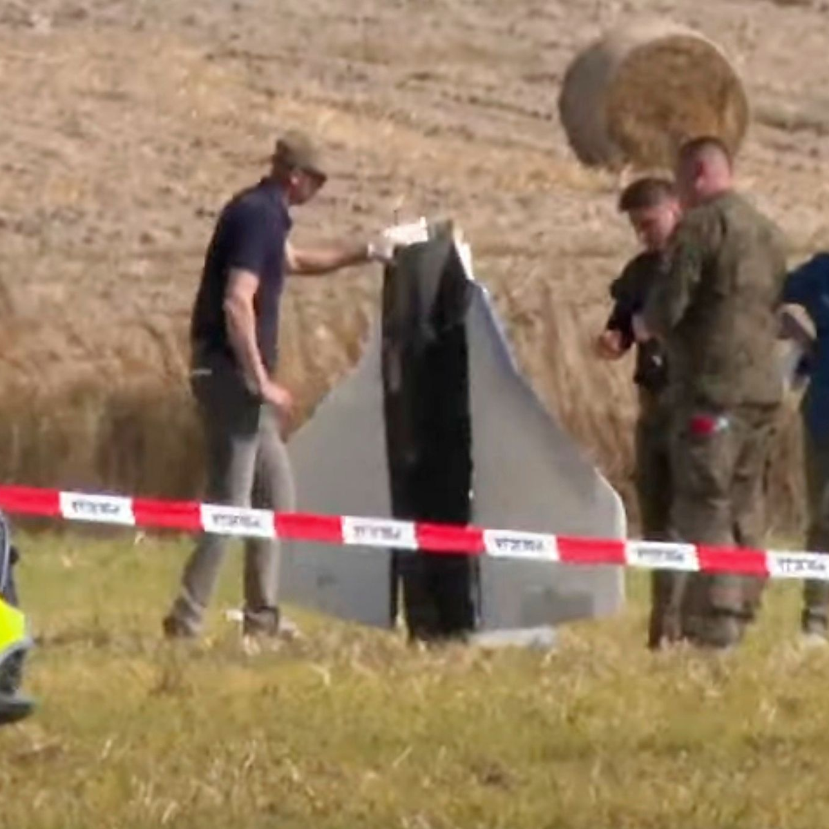Einsatzkräfte von Polizei und Militärpolizei sichern Teile einer beschädigten Drohne. - Foto: Rafal Niedzielski/AP/dpa
