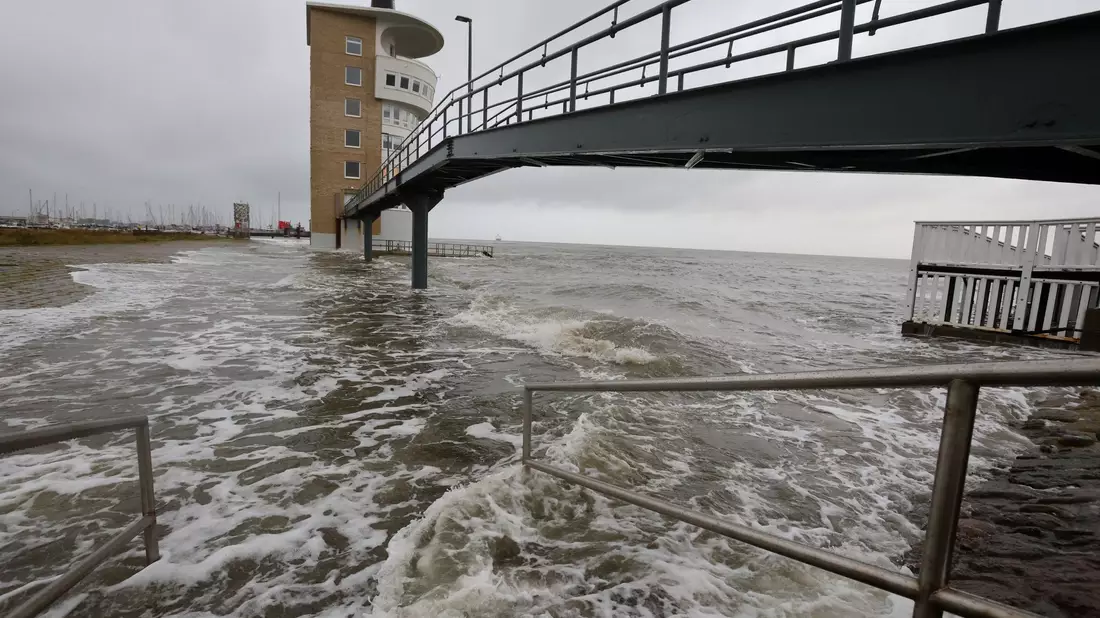 An der Alten Liebe überschwemmt die Nordsee bei einer Sturmflut das Hafengebiet. - Bild: Christian Butt/dpa