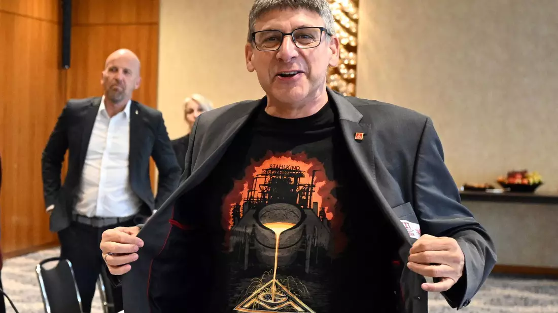 Zum Beginn der Tarifverhandlungen in der Stahlindustrie überreicht der Verhandlungsführer der IG Metall, Knut Giesler, zwei T-Shirts an den Verhandlungsführer der Arbeitgeber, Reiner Blaschek (2.v.l), sowie den Geschäftsführer des Arbeitgeberverbandes Stahl, Gerhard Erdmann (l). - Bild: Federico Gambarini/dpa