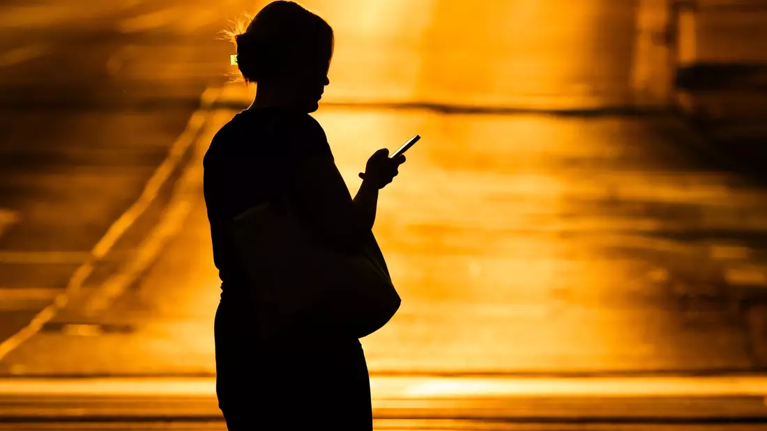 Eine Frau mit Handy - in der Netflix-Doku «Unbekannte Nummer: Der Highschool-Catfish» kommt der Psychoterror via Smartphone. (Symbolbild) - Bild: Julian Stratenschulte/dpa