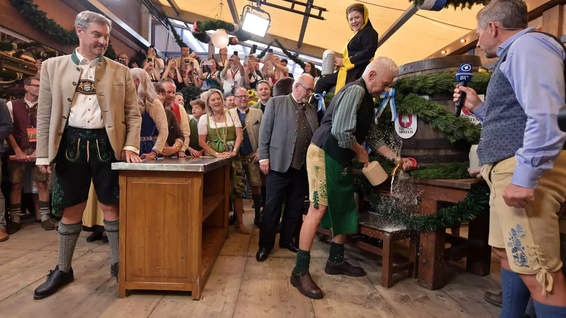 Bayerns Ministerpräsident Söder (l.) und Münchens OB Reiter (r.) stoßen mit ihren Ehefrauen auf eine friedliche Wiesn an. - Bild: Peter Kneffel/dpa