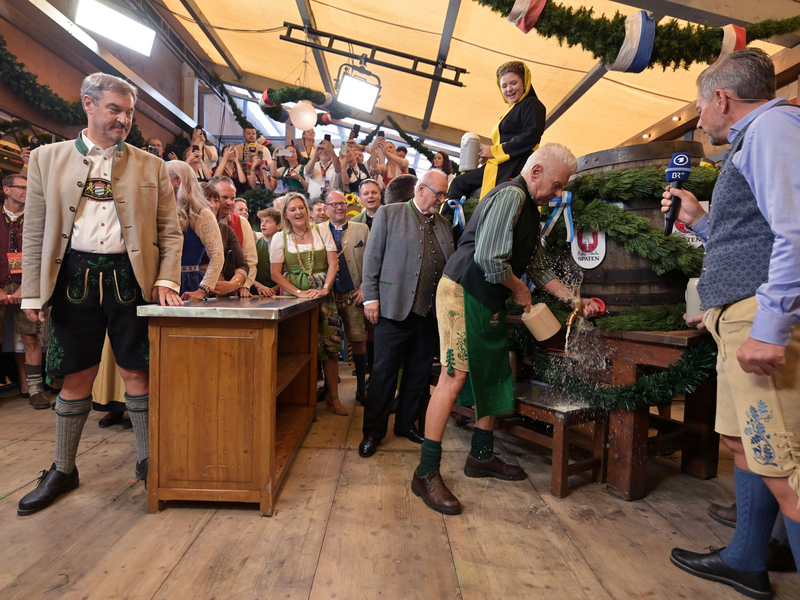 Bayerns Ministerpräsident Söder (l.) und Münchens OB Reiter (r.) stoßen mit ihren Ehefrauen auf eine friedliche Wiesn an. - Foto: Peter Kneffel/dpa