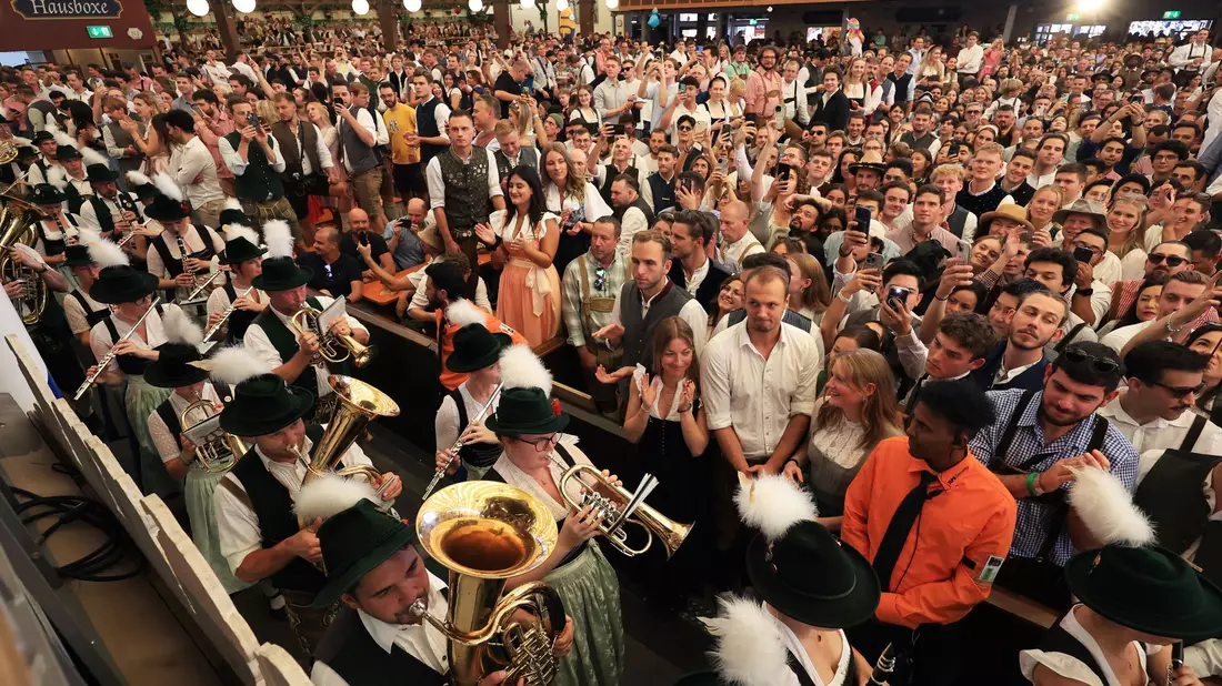 Hochsommerliche Temperaturen auf der Wiesn - da gewährten Schirme zumindest ein wenig Schatten. - Bild: Karl-Josef Hildenbrand/dpa