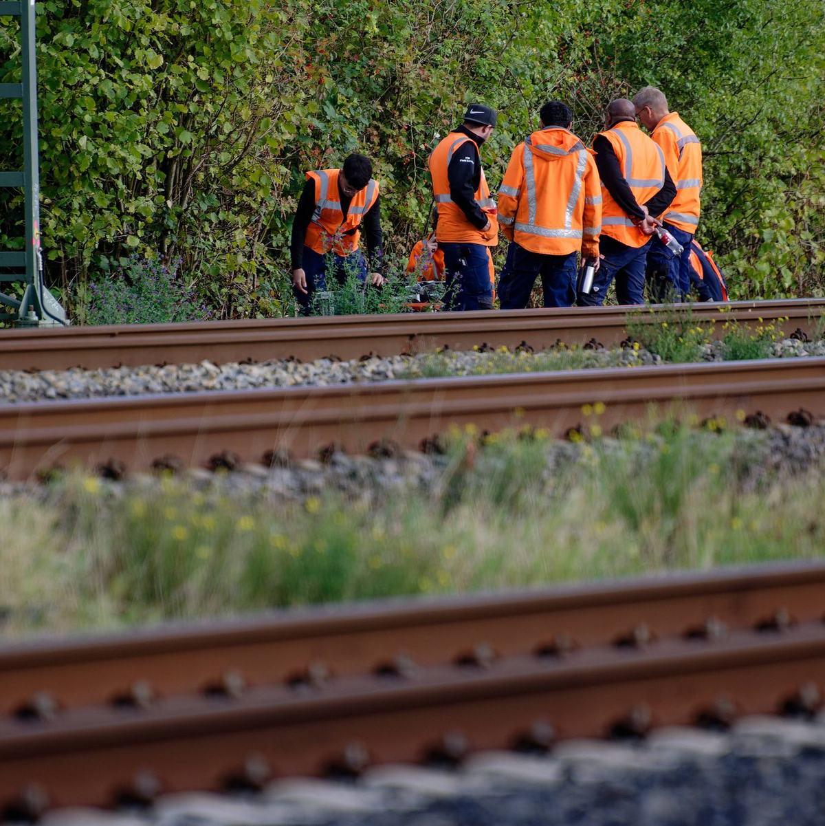 Bahn-Mitarbeiter stehen am Rand der Strecke Köln-Düsseldorf.  - Foto: Henning Kaiser/dpa