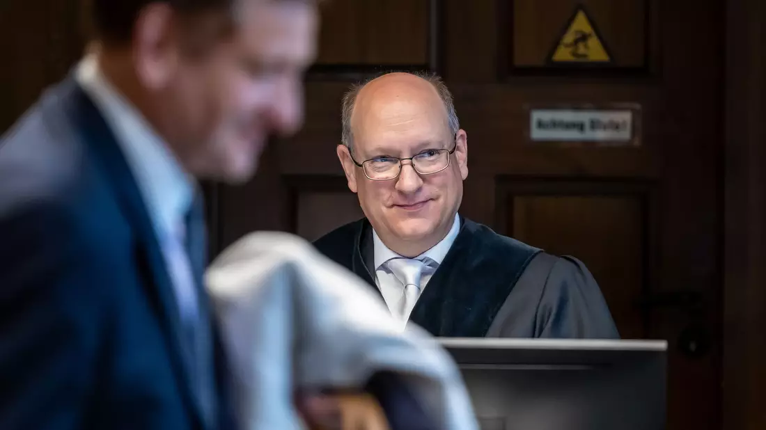Kay Gottschalk (AfD, M), Bundestagsabgeordneter, sitzt mit Anwalt Michael Zischka (r) und Richter Burkhard Niebisch (hinten l) im Gerichtssaal. - Bild: Andreas Gora/dpa