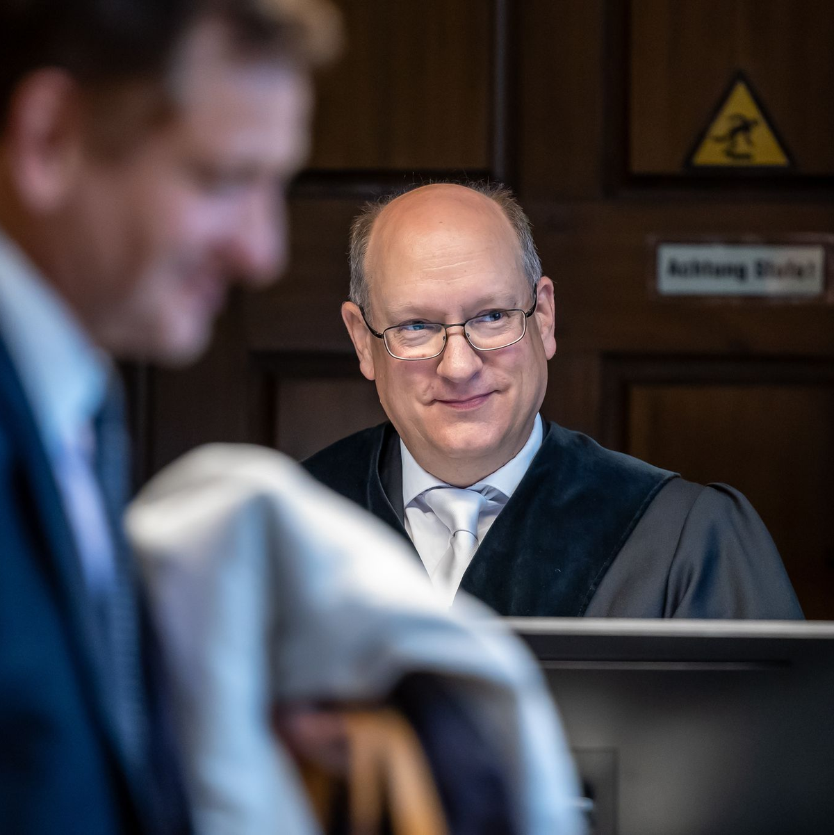 Kay Gottschalk (AfD, M), Bundestagsabgeordneter, sitzt mit Anwalt Michael Zischka (r) und Richter Burkhard Niebisch (hinten l) im Gerichtssaal. - Foto: Andreas Gora/dpa
