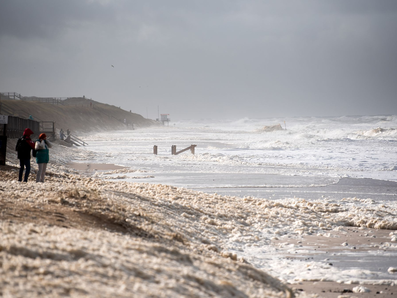 Sturmflut vor Sylt. Das Wetter lockte auch Spaziergänger an die Nordsee. - Foto: Daniel Bockwoldt/dpa