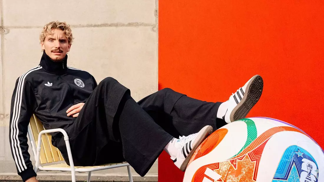 Woltemade posiert lässig mit dem übergroßen Modell des WM-Balls.  - Bild: ---/Adidas/dpa