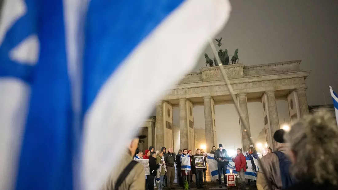 Menschen erinnern am Brandenburger Tor an die Opfer des 7. Oktober. - Bild: Sebastian Christoph Gollnow/dpa