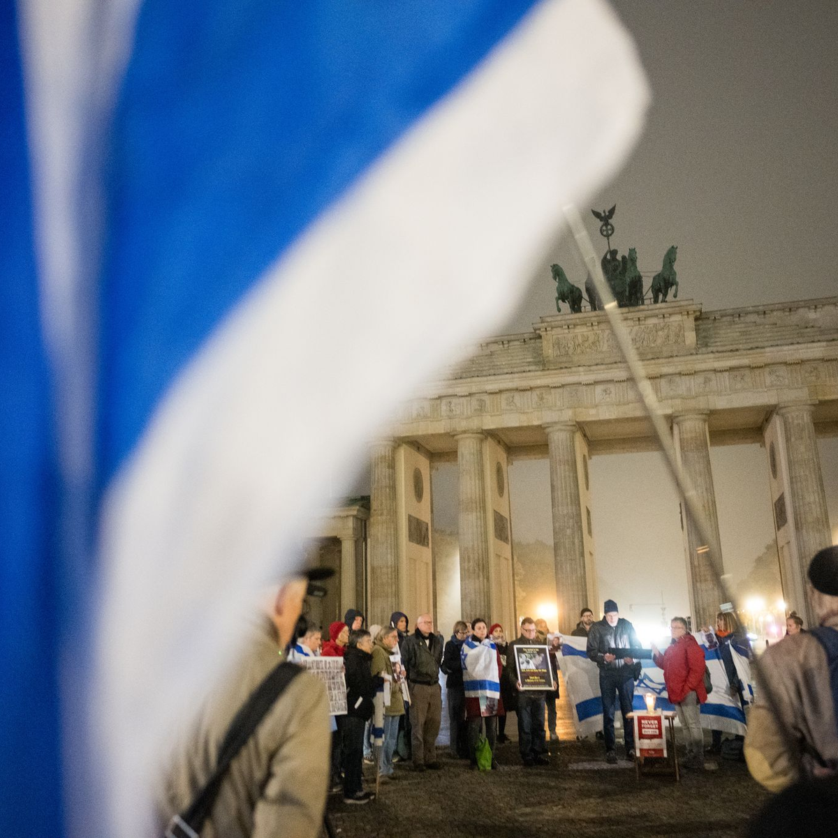 Menschen erinnern am Brandenburger Tor an die Opfer des 7. Oktober. - Foto: Sebastian Christoph Gollnow/dpa