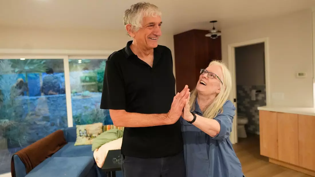 John Martinis steht mit seiner Frau Jean in ihrem Wohnzimmer, nachdem er von seinem Nobelpreis für Physik erfahren hat. - Bild: Mark J. Terrill/AP/dpa