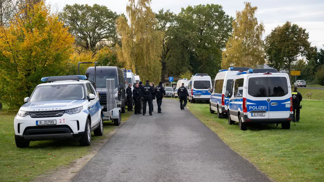 Polizisten stehen vor einem Grundstück in Herzberg. - Bild: Christophe Gateau/dpa