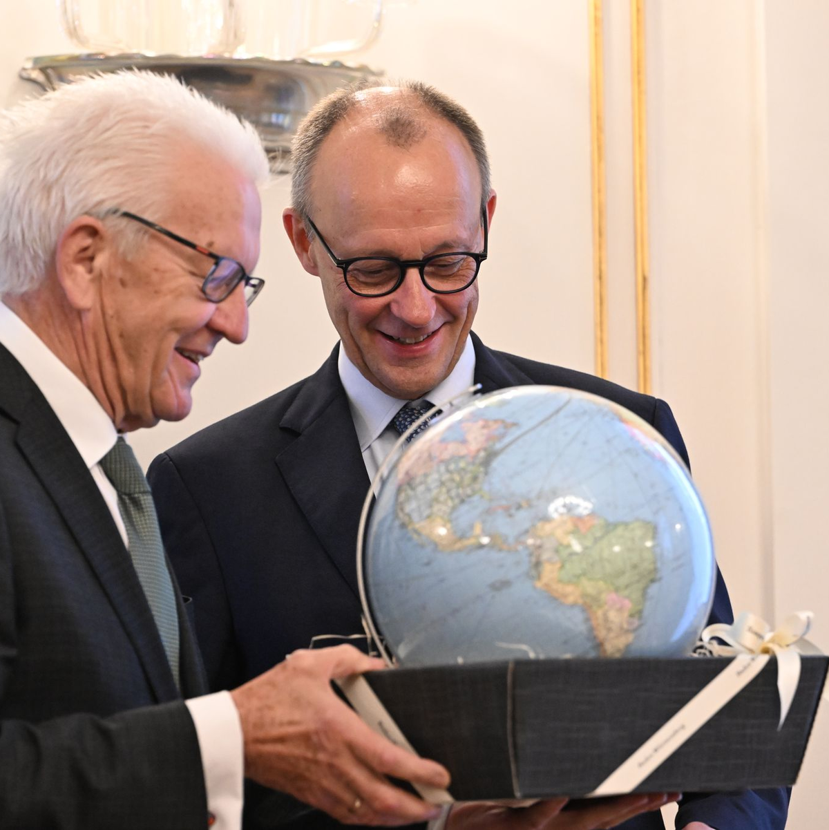 Kretschmann schenkte Merz einen Globus - weil ein Kanzler ja auch Weltpolitik mache. - Foto: Marijan Murat/dpa