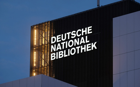 Der Schriftzug Deutsche Nationalbibliothek (DNB) leuchtet an einem 55 Meter hohen Gebäude der früheren Deutschen Bücherei. (Archivbild) - Foto: Sebastian Willnow/dpa