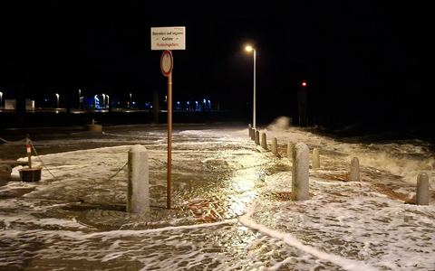 Wellen überspülen die Promenade in Wilhelmshaven.  - Foto: Kai Moorschlatt/dpa