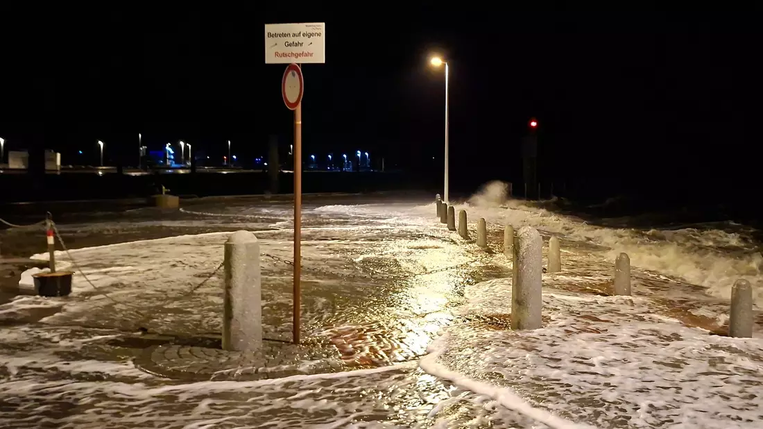 Wellen überspülen die Promenade in Wilhelmshaven.  - Bild: Kai Moorschlatt/dpa