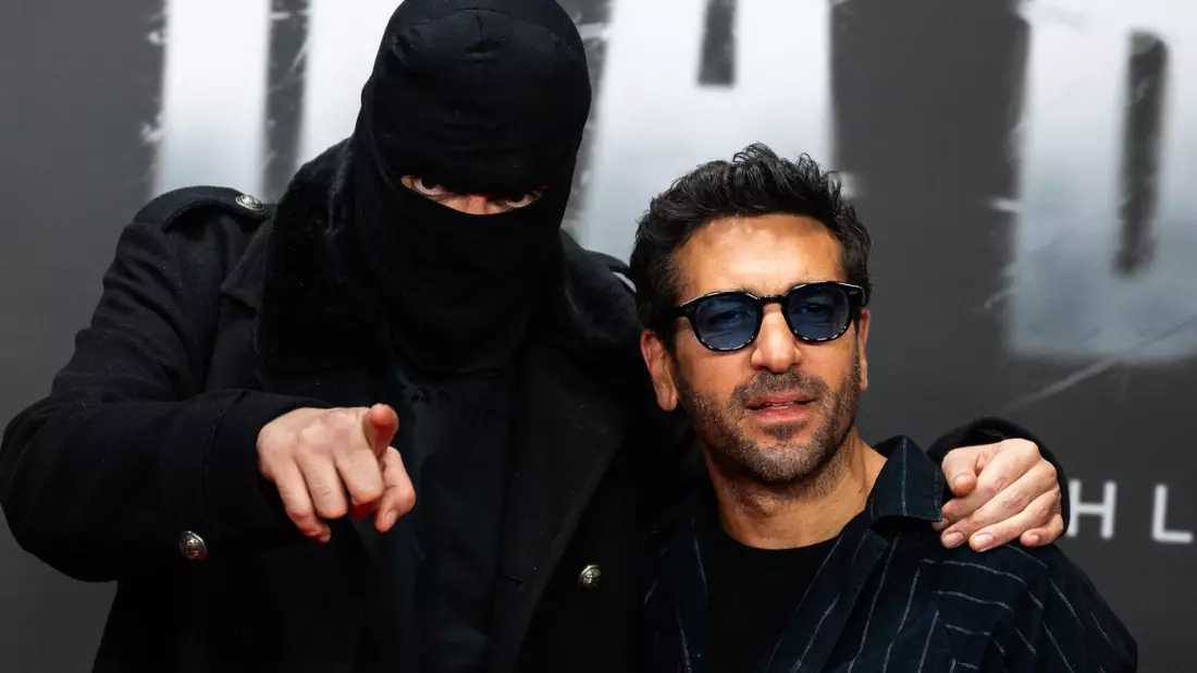 Haftbefehl (bürgerlich Aykut Anhan und hier verhüllt) besucht mit seiner Frau Nina Anhan eine Kinoaufführung der Dokumentation «Babo - Die Haftbefehl-Story» in Berlin. (Archivbild) - Bild: Christophe Gateau/dpa