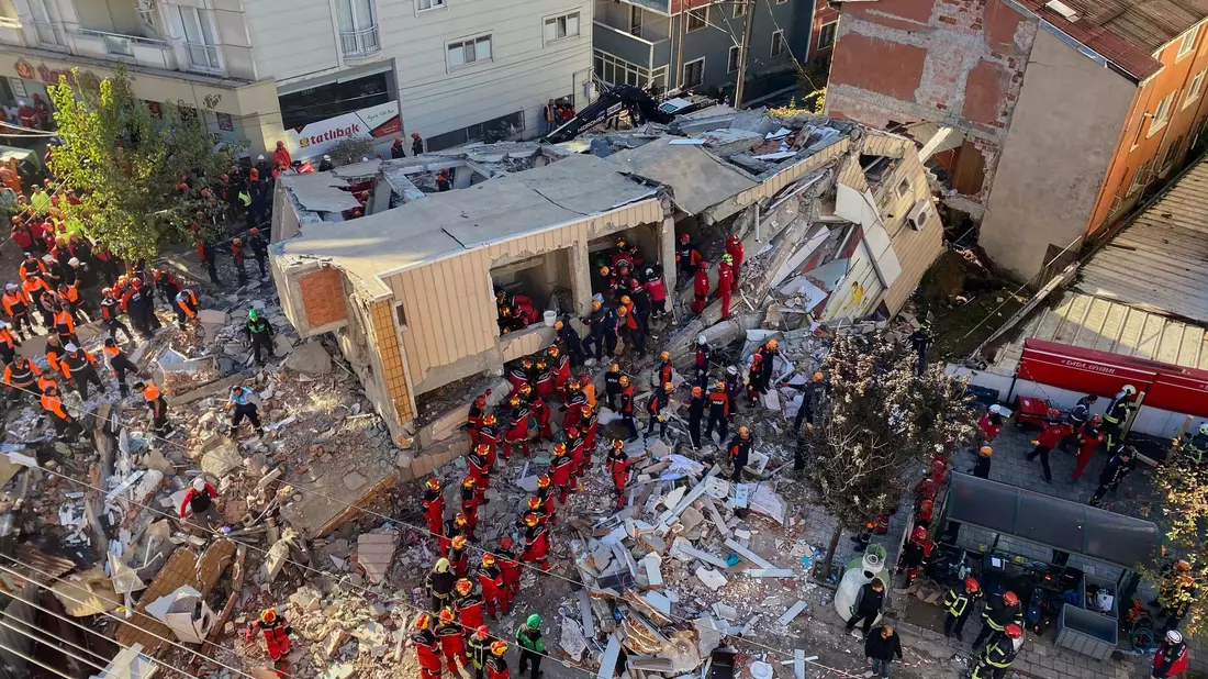 Feuerwehrleute und Rettungskräfte suchen nach dem Einsturz eines Wohngebäudes nach Verschütteten. - Bild: Cihan Atik/IHA/AP/dpa