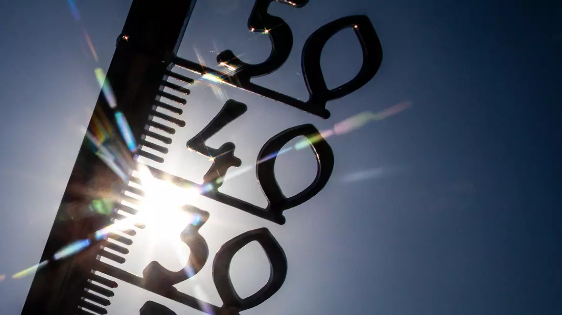 Vor einem wolkenlosen blauen Himmel zeigt ein Außenthermometer in einem Garten bereits am Vormittag über 30 Grad Lufttemperatur an. (Illustration) - Bild: Jens Büttner/dpa