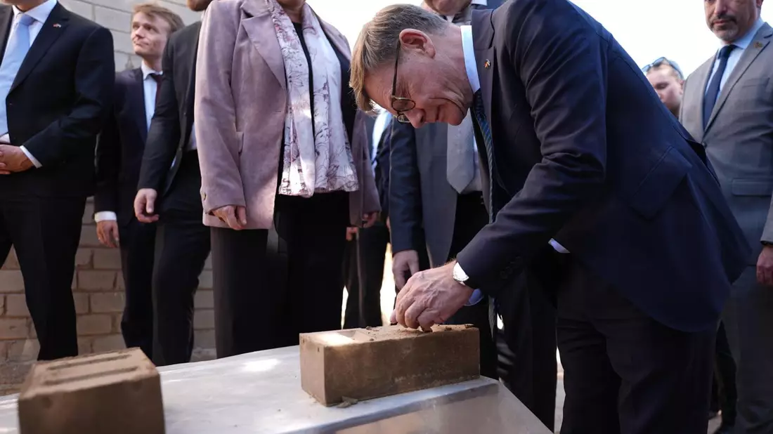 Außenminister Johann Wadephul (CDU) macht sich ein Bild von einem Projekt, das Binnenvertriebenen ermöglichen soll, günstig mit Lehmziegeln zu bauen.  - Bild: Marcus Brandt/dpa