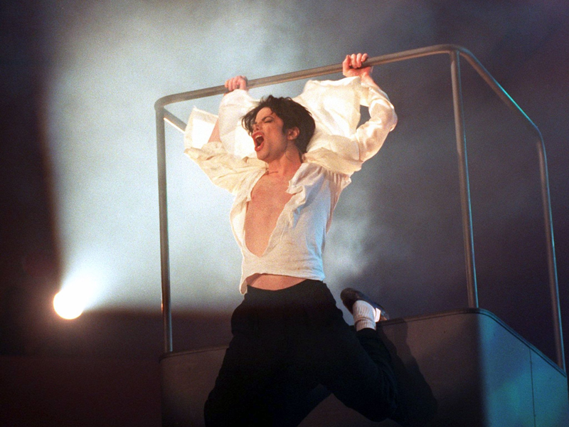 Michael Jackson am Geländer der Hebebühne in der Duisburger Rhein-Ruhr-Halle am Abend des 4. November 1995. (Archivbild) - Foto: Achim Scheidemann/dpa