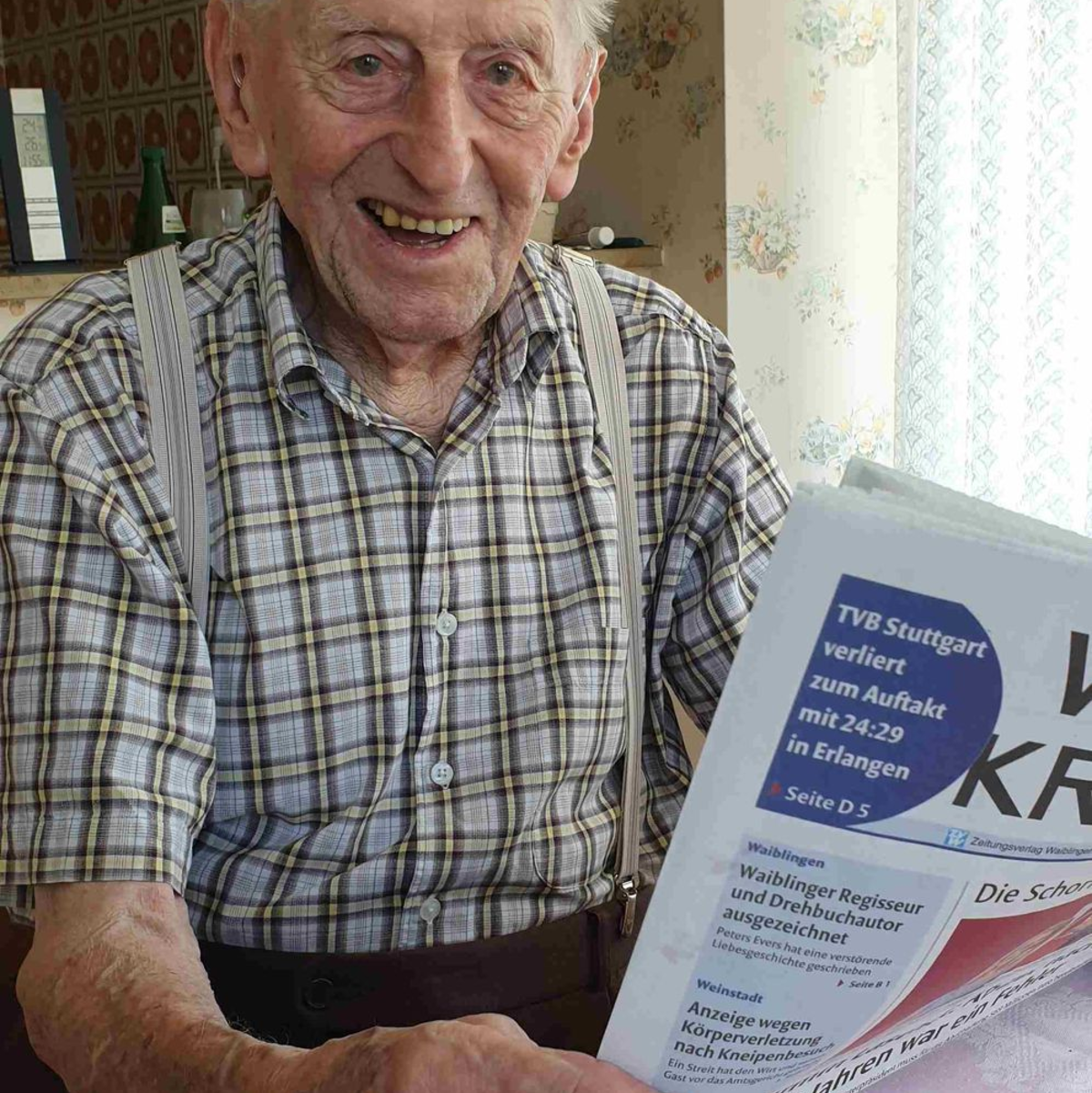 Karl Haidle sitzt an seinem 104. Geburtstag an einem Tisch und liest Zeitung. - Foto: Sebastian Striebich/ZVW/dpa