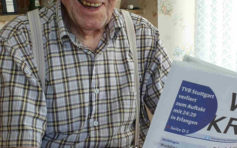 Karl Haidle sitzt an seinem 104. Geburtstag an einem Tisch und liest Zeitung. - Foto: Sebastian Striebich/ZVW/dpa