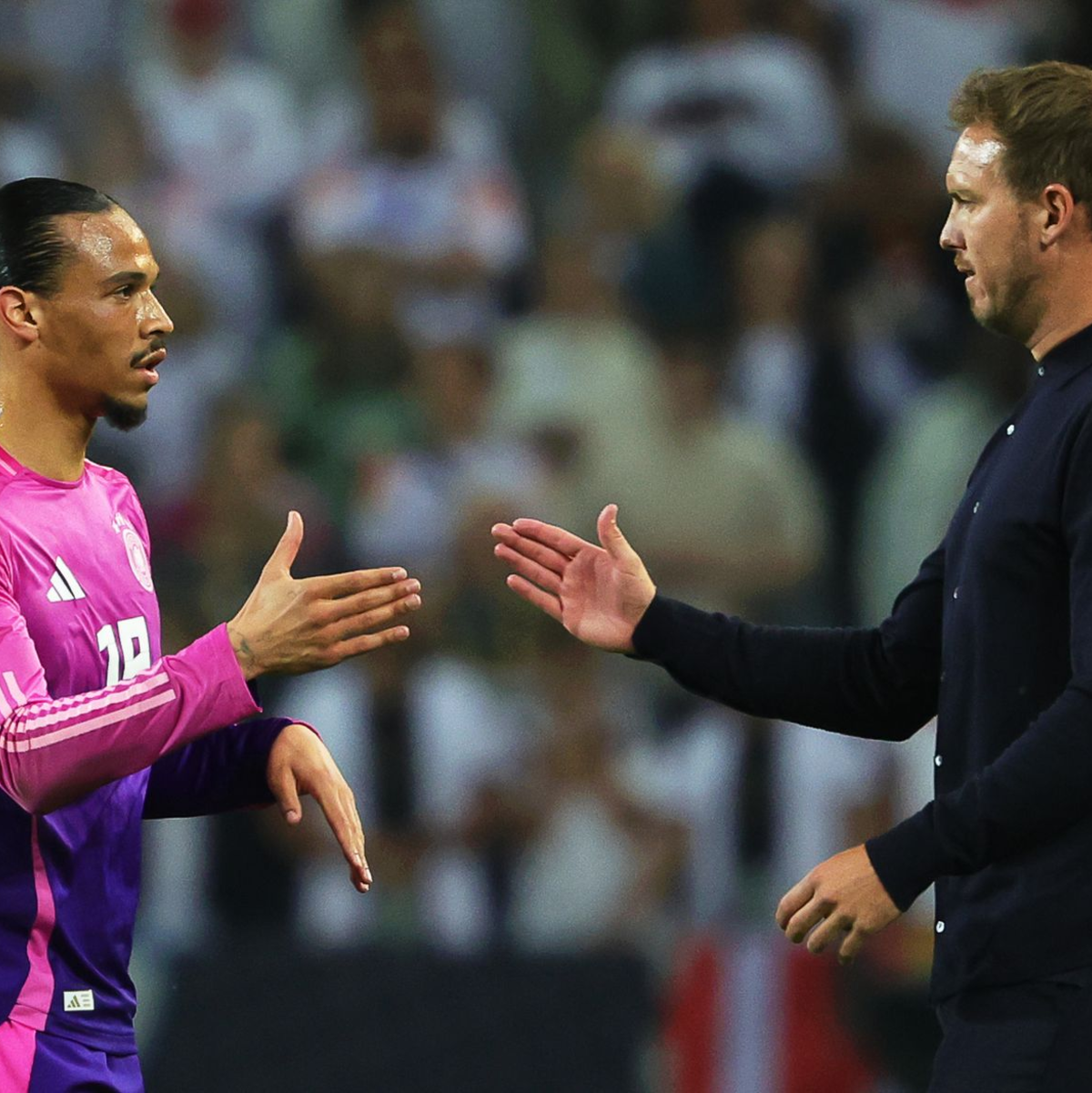 Leroy Sané (l) und Julian Nagelsmann klatschen nach einem Spiel ab. (Archivbild)  - Foto: Christian Charisius/dpa