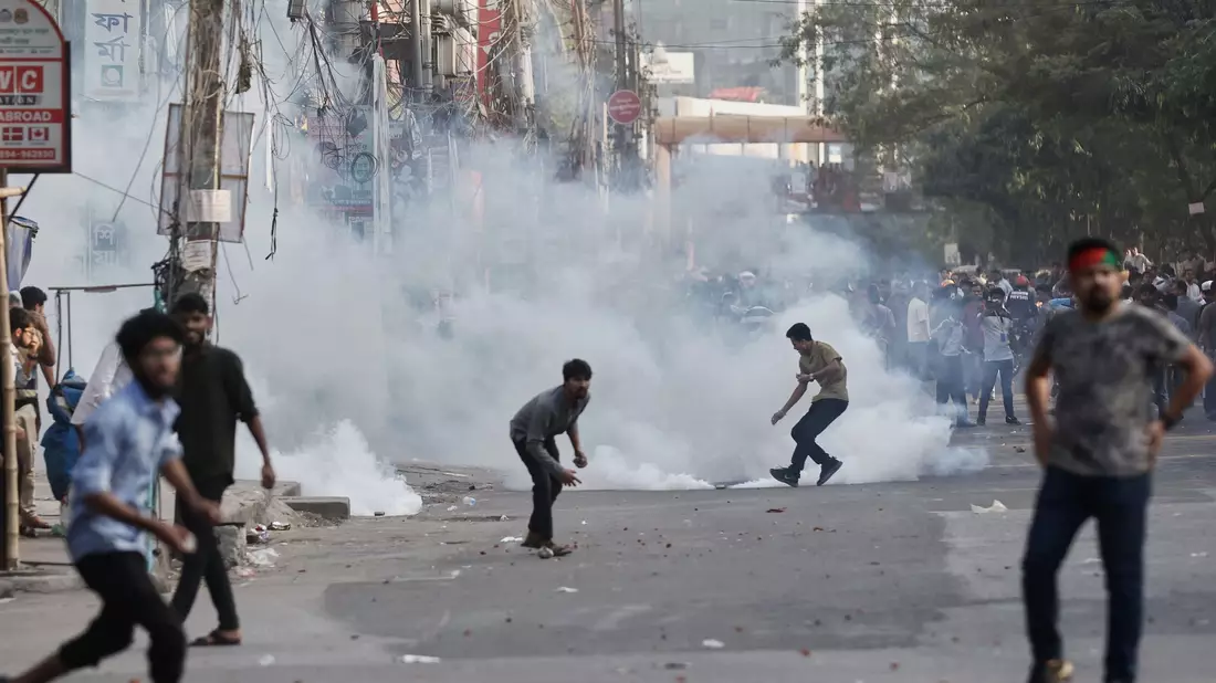 Demonstranten werfen Steine und rufen Parolen während einer Auseinandersetzung mit der Polizei in Bangladesch. - Bild: Rajib Dhar/AP/dpa