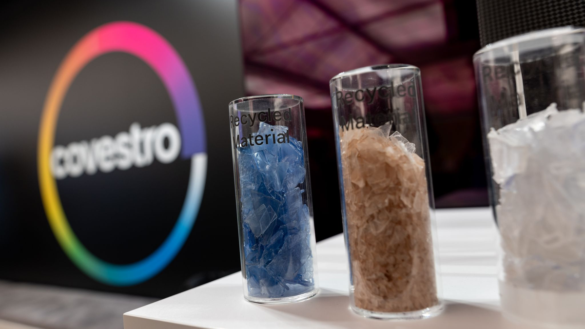 Eine deutsche Firma wird arabisch: Das Logo des Spezialchemie-Konzerns in einem Firmen-Showroom, davor Gläser mit Covestro-Materialien.  - Foto: Fabian Strauch/dpa