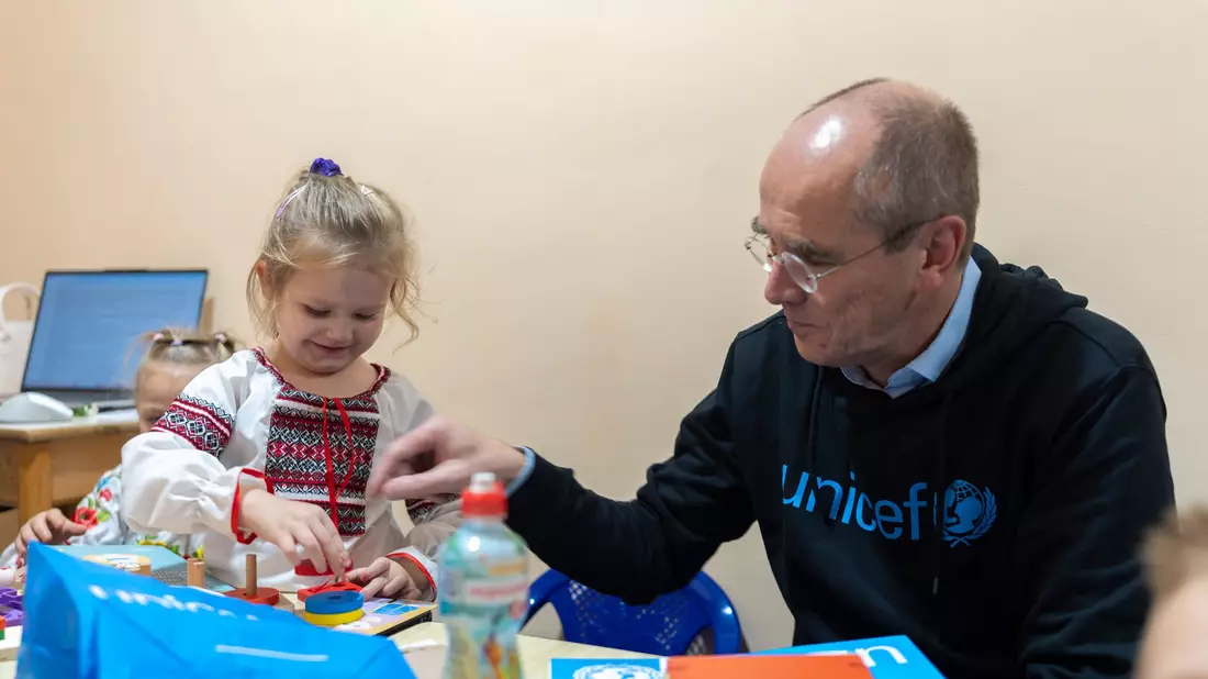 Der Geschäftsführer von Unicef Deutschland, Christian Schneider, mit einem ukrainischen Vorschulkind in einem Schutzraum unter der Erde: Das Kinderhilfswerk hilft Schulen und Kindergärten in dem vom Krieg geprägtem Land. - Bild: -/Unicef/dpa