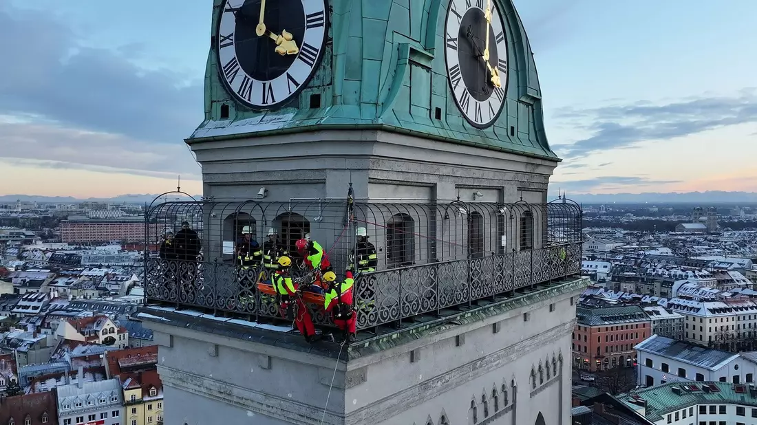 Kräfte der Berufsfeuerwehr München sind am Turm der Kirche St. Peter im Einsatz.  - Bild: -/Berufsfeuerwehr München/dpa