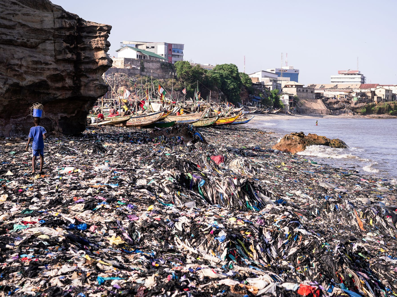 Ein Sandstrand, dessen Sand gar nicht mehr zu sehen ist: Massen an Klamotten vermüllen diesen Küstenabschnitt von Accra.  - Foto: Kevin McElvaney/Deutsche Umwelthilfe/dpa