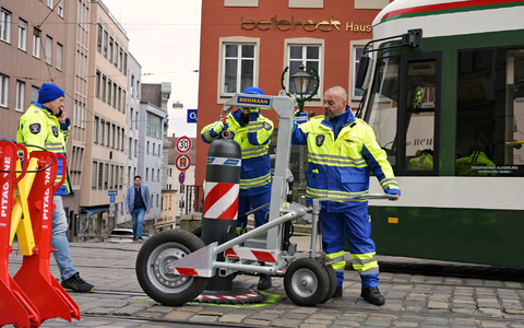 Zu den Hauptverkehrszeiten müssen Sicherheitsmitarbeiter neben dem Augsburger Christkindlesmarkt jede Stunde dutzendfach schwere Poller bewegen, damit die Straßenbahnen durchfahren können. - Foto: Malin Wunderlich/dpa
