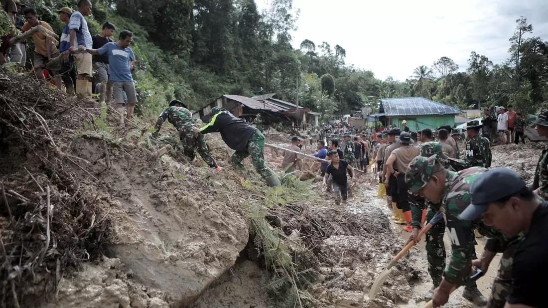 Rettungskräfte und Dorfbewohner beseitigen Schlamm. - Bild: Gatha Ginting/XinHua/dpa
