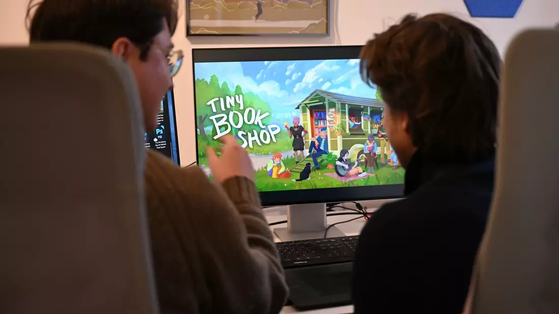 Als Bachelor-Arbeit an der Uni entstanden, inzwischen ein großer Verkaufserfolg: Das Spiel «Tiny Bookshop» mit ihren beiden Entwicklern David Zapfe-Wilde (links) und Raven Rusch.  - Bild: Wolf von Dewitz/dpa