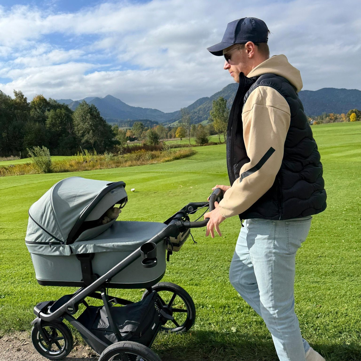 Biathlet Johannes Kühn schiebt seine Tochter im Kinderwagen.  - Foto: -/Johannes Kühn/dpa