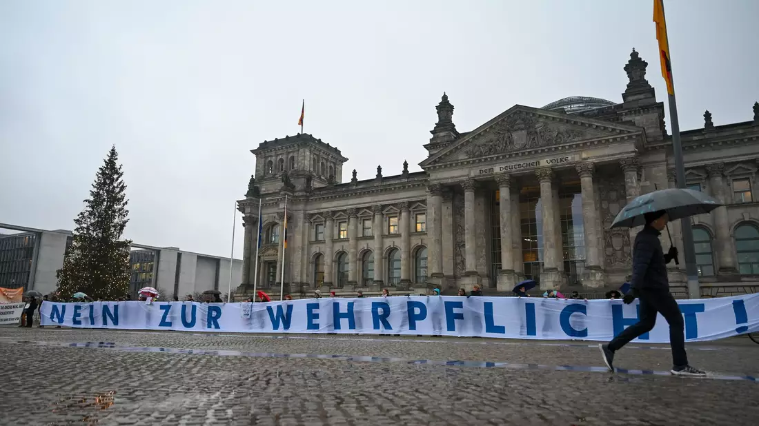 Bundestag billigt Wehrdienstgesetz, junge Menschen protestieren dagegen - Bild: Christophe Gateau/dpa